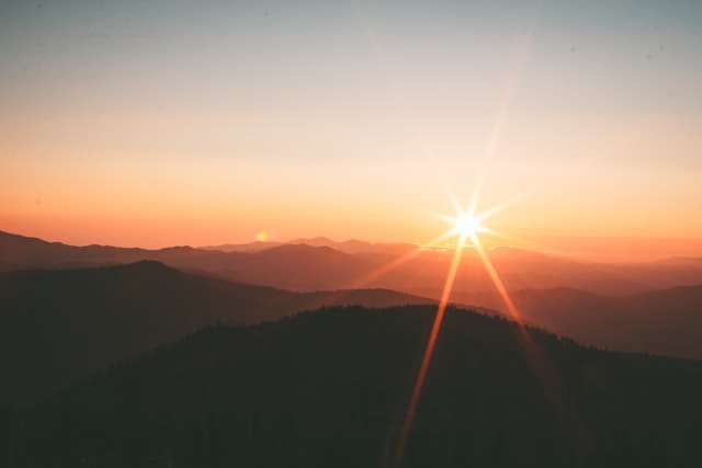 Sun setting over mountain ridges